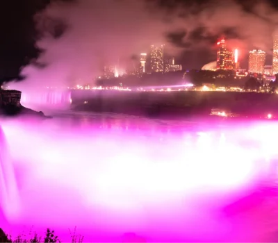 Niagara Falls is illuminated pink.